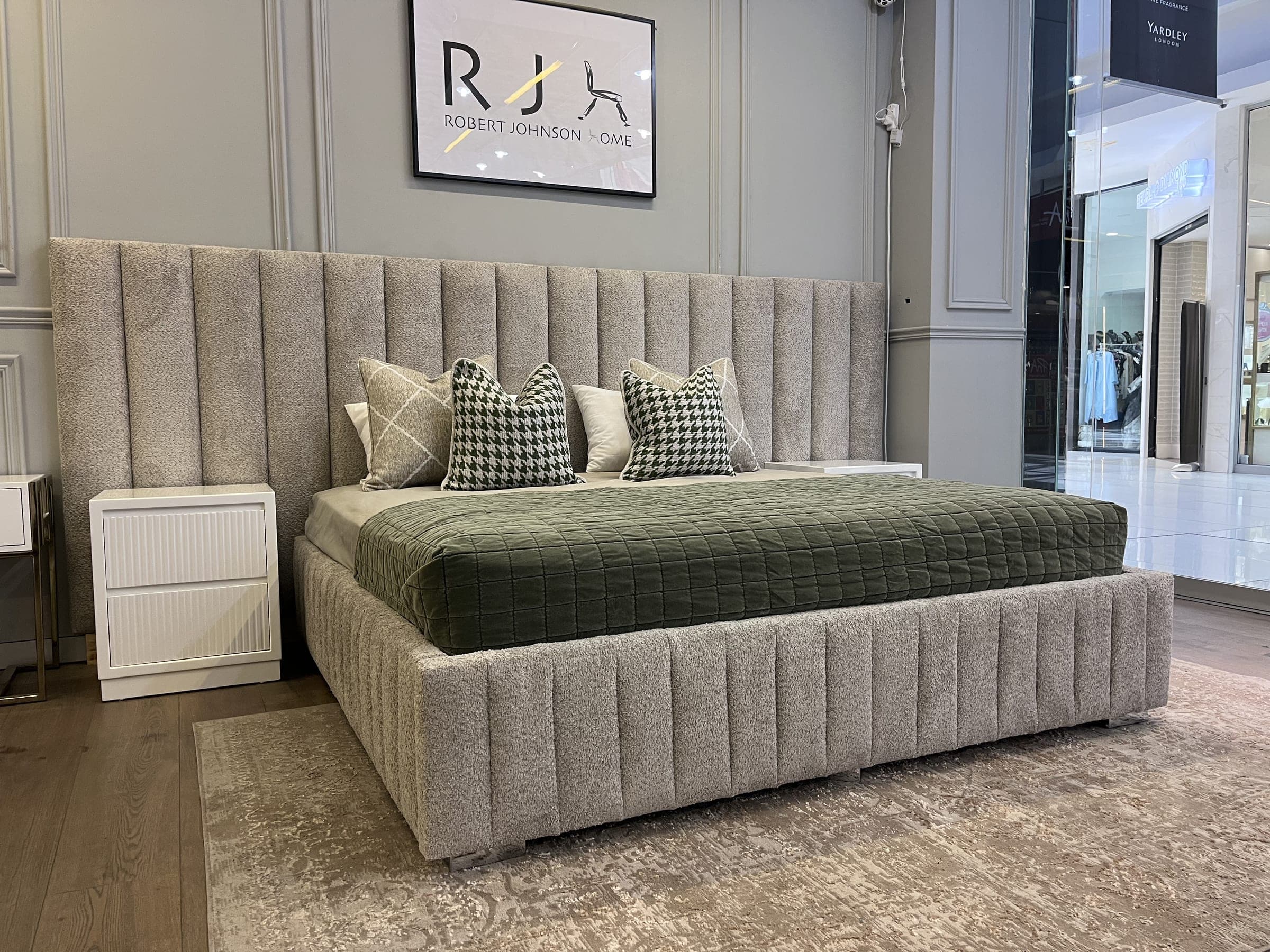 Channel-upholstered bed in cream boucle with a green throw